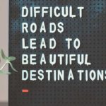 Bulletin board with message Difficult Roads Lead to Beautiful Destinations